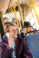 man using smartphone in bus