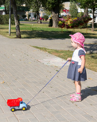Child playing with a toy car