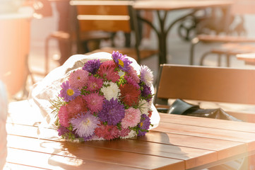 flowers aster bouquet on the table in autumn in a cafe,filter applied