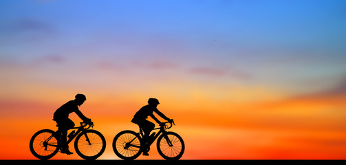 Fototapeta na wymiar Silhouette man and bike relaxing on blurry sunrise background