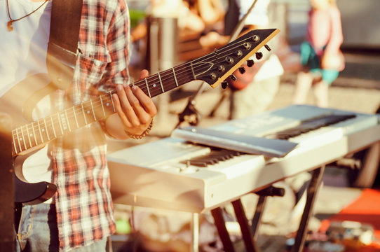 guitarist sets up an electric guitar before the concert begins on the street,filter applied