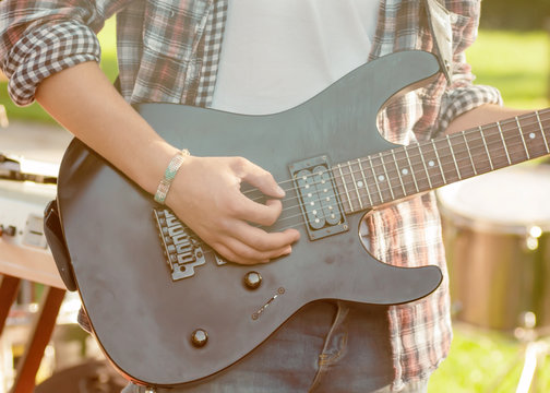 guitarist sets up an electric guitar before the concert begins on the street,filter applied