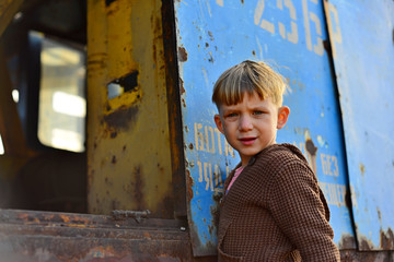 Fototapeta na wymiar A little boy looks into the void of an iron mechanism