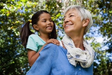 Low angle view of happy grandmother giving piggyback to