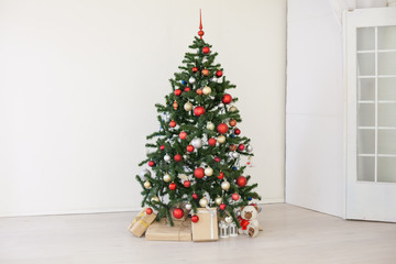 Christmas tree with red gifts in the white room Christmas