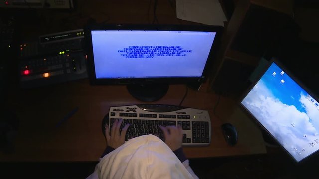 Hacker in hood, cracked the code with computers.