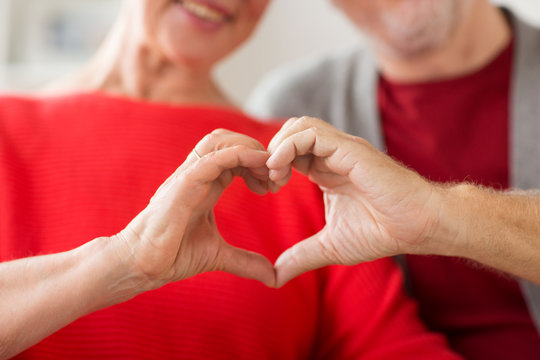 close up of senior couple showing hand heart sign