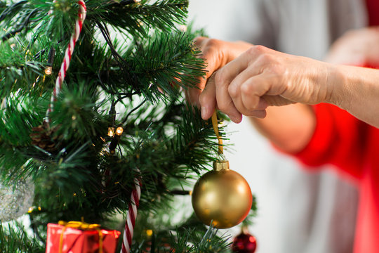 Close Up Of Senior Woman Decorating Christmas Tree