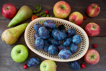 Harvest of autumn fruits on wooden background. Assorted fruits.