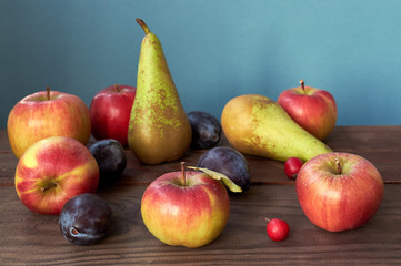 Harvest of autumn fruits on wooden background. Assorted fruits.