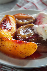Baked plums and peaches with ice cream and honey