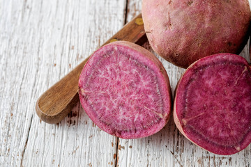 Raw sweet potatoes on wood background with filter effect retro vintage style