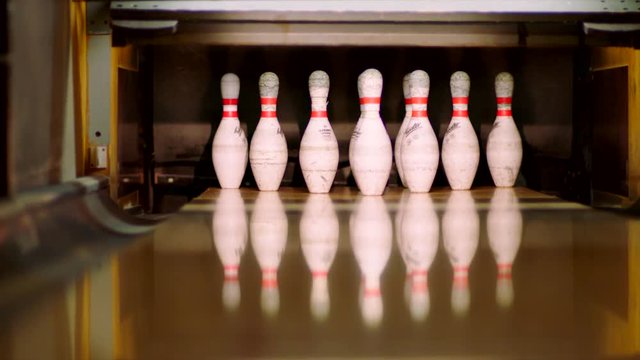 Bowling ball knocking pins on the bowling lane. Slow motion
