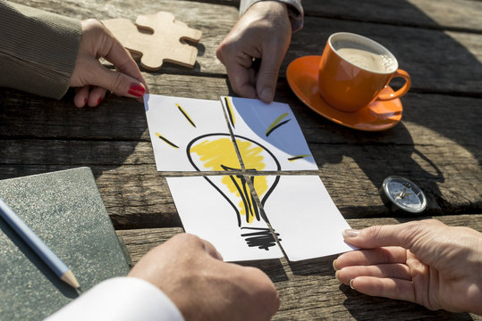 Light bulb on a rustic wooden table outdoors in the sunlight