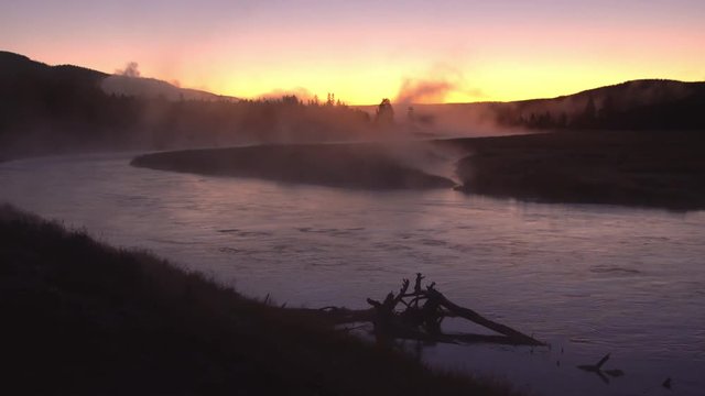 Steam rising from river flowing at sunrise in Wyoming.
