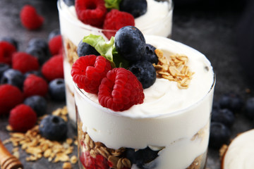 Glass jar of homemade granola with yogurt and fresh berries