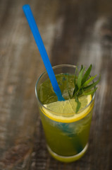 Tarragon lemonade with lemon in a glass on wooden background