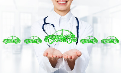 Close up of female hand showing car symbol made with gears and cogwheels
