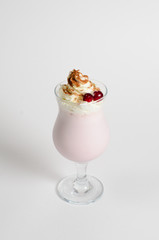 Milkshake with whipped cream and berries in a glass on white background