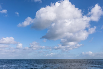 Naklejka na ściany i meble Beautiful sea under cloudy blue sky