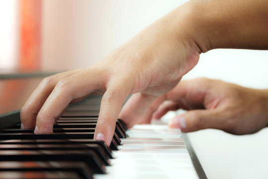 Man hands playing piano. Side view. Art and music background.