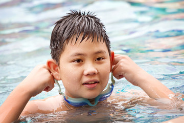 Cute happy boy swimming
