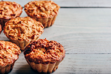 Cooked muffins on wooden background.