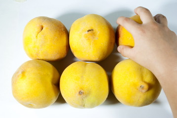 Group of organic peaches in Guatemala, seasonal fruit. Prunus persica. Hand of boy grabbing peach