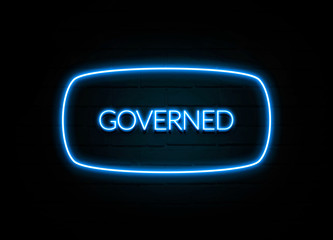 Governed  - colorful Neon Sign on brickwall