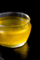 Nice ghee in a glass bowl over black background.