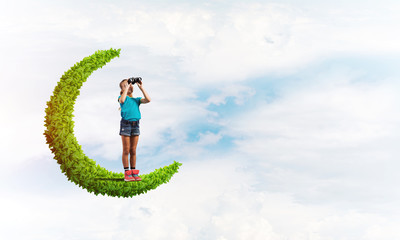 Concept of careless happy childhood with girl on green moon