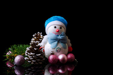 Obraz premium Christmas composition: snowman, christmas balls, and cone isolated on black, free space.