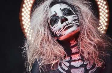 Halloween female skull makeup with creative lightening.