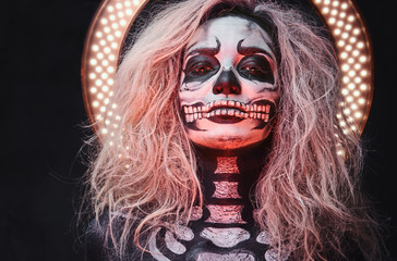 Halloween female skull makeup with creative lightening.