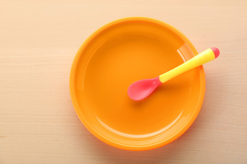 Bright baby tableware on wooden table