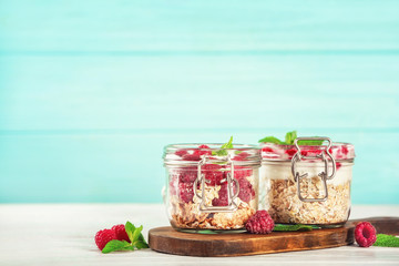 Jars with oat flakes and fresh berries on wooden background