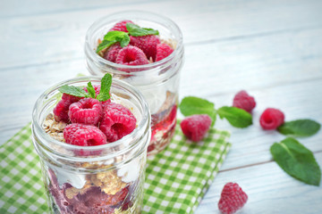 Jars with oat flakes and fresh berries on wooden background
