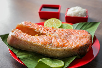 Plate with delicious salmon steak on table, closeup