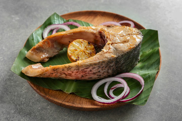 Plate with delicious fish steak on table