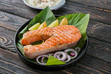 Plate with delicious salmon steak on table
