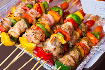 Skewered on wooden sticks tasty pork meat and vegetables mix, grilled meat