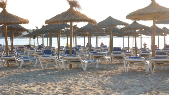Empty beach with sun loungers and straw umbrellas in the evening in Santa Ponsa Mallorca Spain