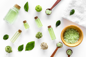 Fototapeta na wymiar bath salt in herbal cosmetic set with tea olive leaves on white background top view pattern