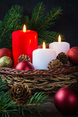 Fototapeta na wymiar Christmas decoration burning candles spruce branches, Christmas balls on a dark background with copy space, festive mood and atmosphere