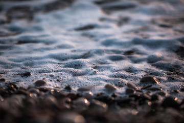 tide of a small wave on a stone beach