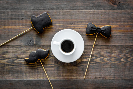 Black tie, mustache and hat cookies on sticks for happy father's day present cookies wooden background top view