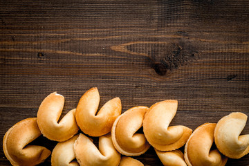 Chinese fortune cookie with prediction on wooden background top view space for text