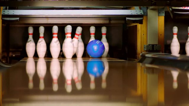 Bowling ball knocking pins on the bowling lane. Slow motion