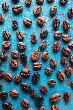 Roasted coffee beans on blue background.