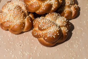Buns with sesame seeds on a wooden background